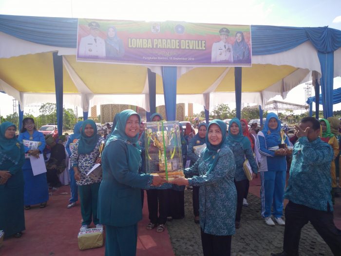 Ketua PKK Pelalawan Hj.Ratna Mainar Harris Menyerahkan Piala Tetap Kepada Juara Umum PKK Kecamatan Langgam yang Ketua nya Rohanita Sungeng